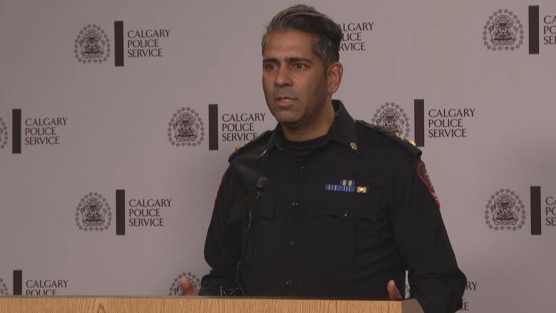 A man in a police uniform talks into a microphone. 