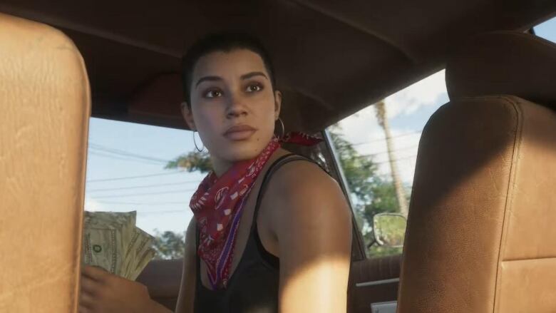 Screenshot from video game of a Latin American woman with long dark hair and a red bandana around her neck, sitting in a car.