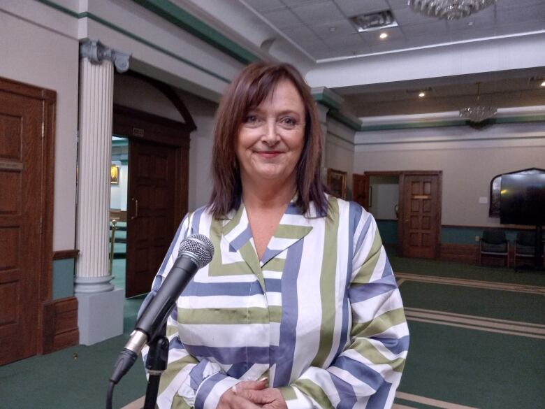 Woman in white, blue, green and purple stripped blouse.