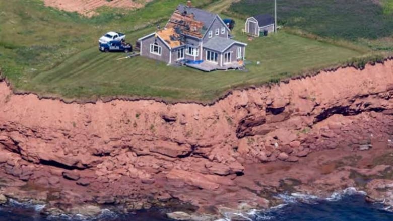 House close to red cliff.