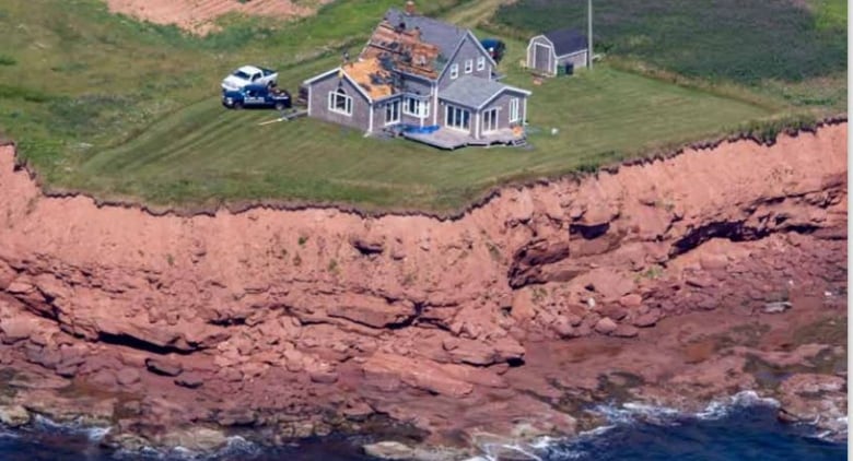 House close to red cliff.