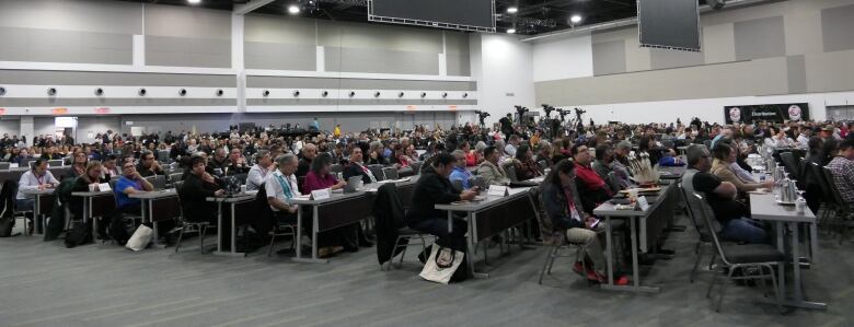 A large group gathered in a convention room.