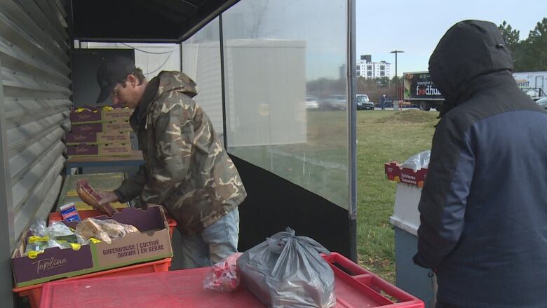 Two people are shown at a Windsor, Ont., food bank.