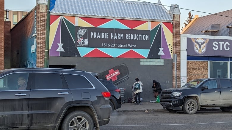 A black building with a colourful exterior features a black banner with the name 