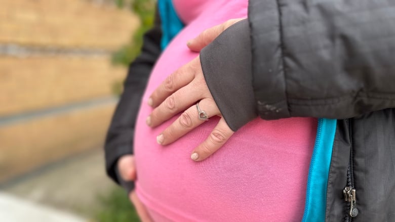 Woman holds baby bump