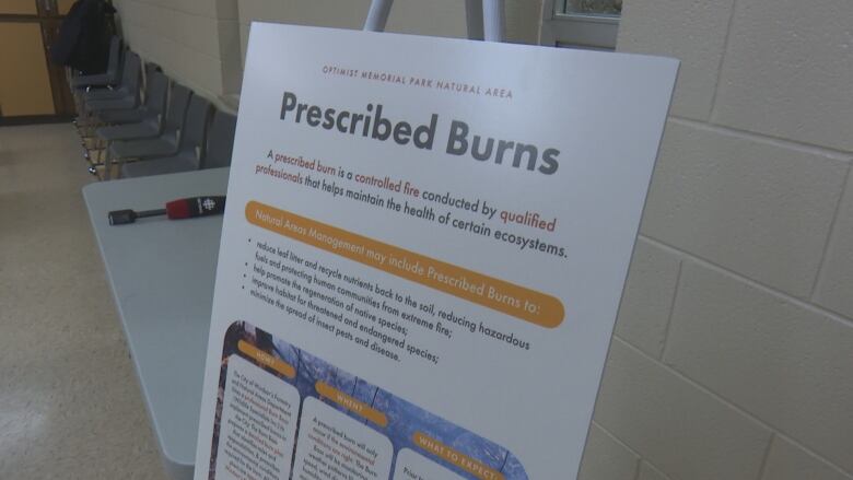 A poster explaining the purpose for prescribed burns is displayed at a city of Windsor neighbourhood meeting at Optimist Memorial Park.