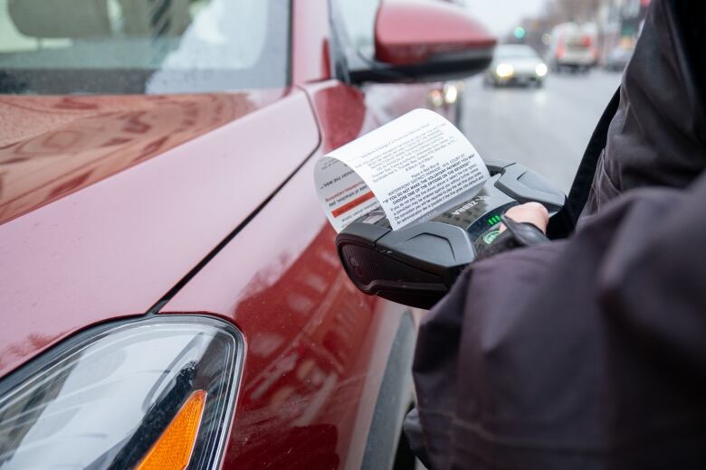 A parking ticket is printed by a parking attendant.