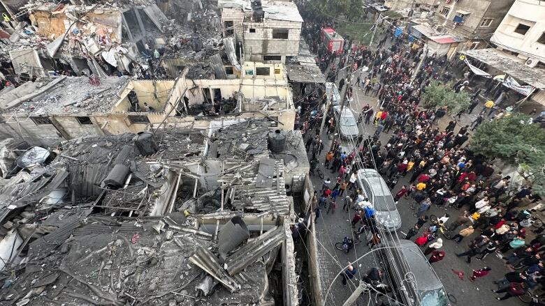 People search through the rubble of damaged buildings in Gaza.