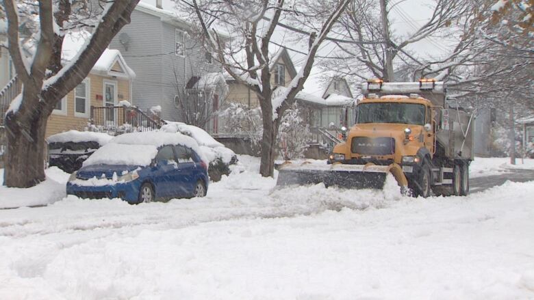 A plow pushes snow on a street.