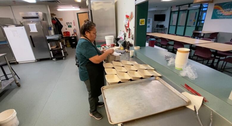 A woman setting up take out containers 