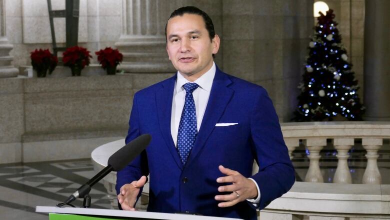 A man in a suit standing at a podium.