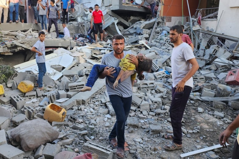 Palestinian carries a child killed in an airstrike on the buildings of Abu Asad family in Deir el-Balah, southern Gaza Strip, Saturday, Oct. 21, 2023. 