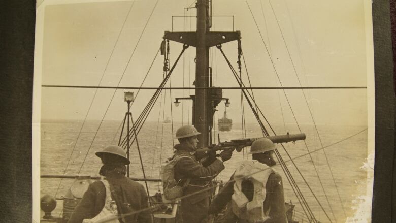 A black and white photo shows some Canadians on board a convoy heading across the Atlantic in December 1939.