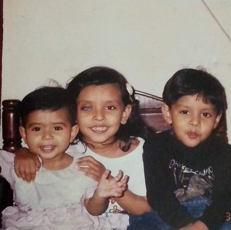 An old photo of three siblings.