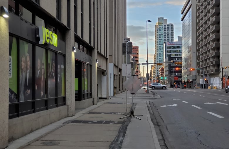 An empty downtown street with traffic lights in the distance.