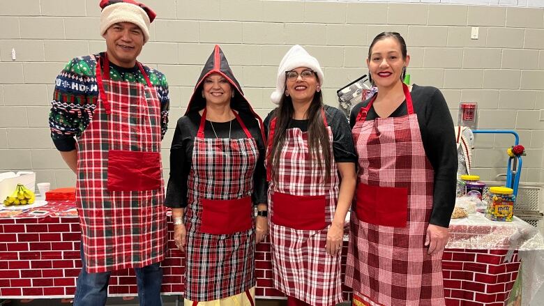 The three Lennox Island council members surround the Chief wearing a mixture of Mi'kmaw regalia and festival Christmas aprons and hats.