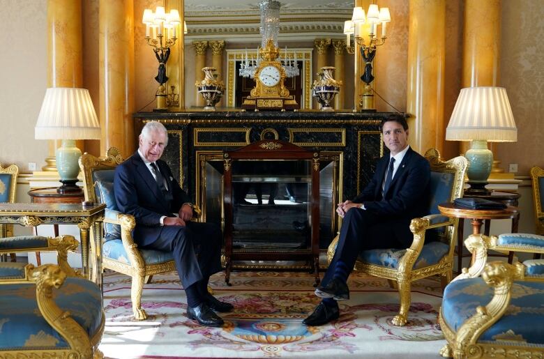 King Charles sits with Prime Minister Justin Trudeau at Buckingham Palace. 