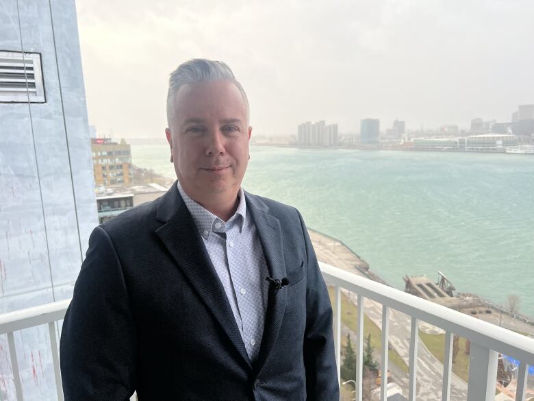 Man stands with view of detroit in background