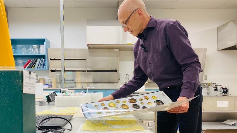 A researcher looks over a poster at his laboratory.