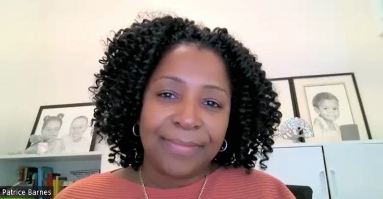 A woman with black curly hair wearing a pink shirt