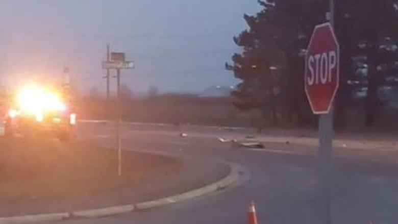 The lights of a truck flash as it drives down a road.