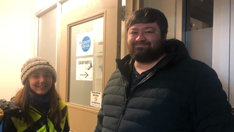 Man and child in winter coats smile for a picture