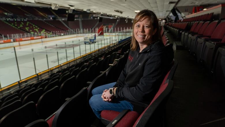 Woman sits in hockey area stands