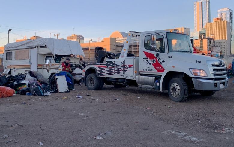 A tow truck hooked up to a white van.