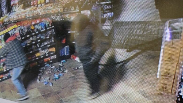 In the screen shot of security footage two people can be seen in the store