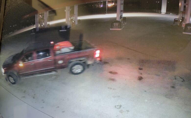 In a screen shot of security footage, a dark coloured GM truck can be seen outside of the business  