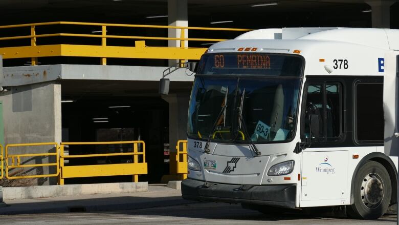 A bus is next to a building.