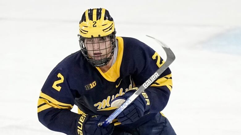 A hockey player with a full cage helmet.