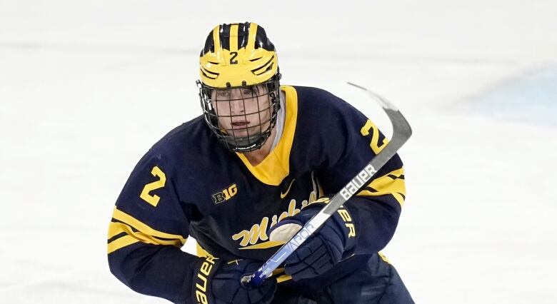 A hockey player with a full cage helmet.