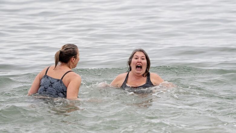 A polar bear swimmer is shown with her mouth wide open as she reacts to taking a dip in the frigid Atlantic Ocean.