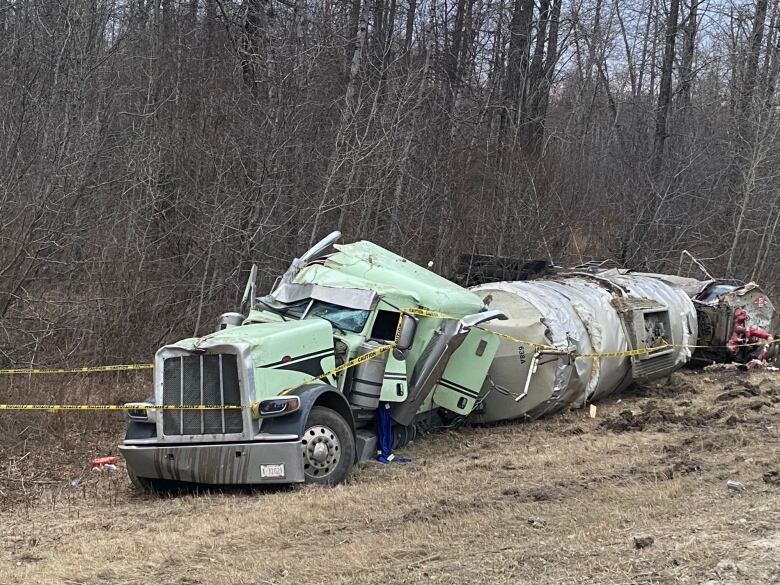 A truck that was squashed in an accident, with yellow tape around it. 