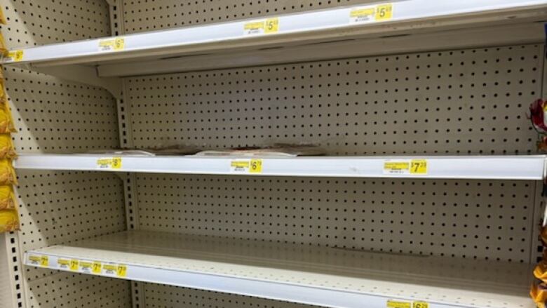 Several rows of empty store shelves are pictured.