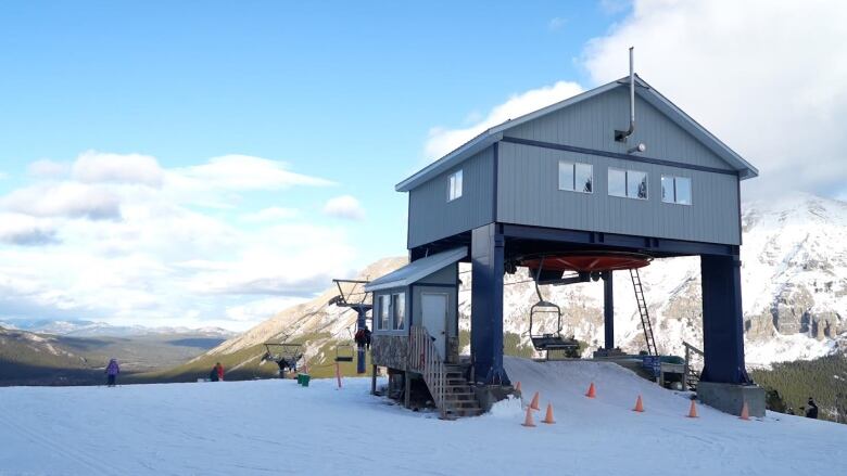 A chairlift with mountains behind. 