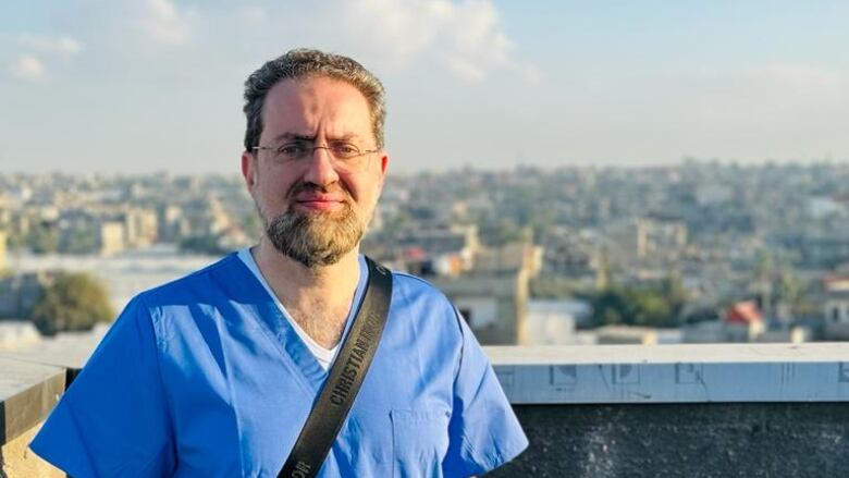 man in medical uniform with view of gaza in the background