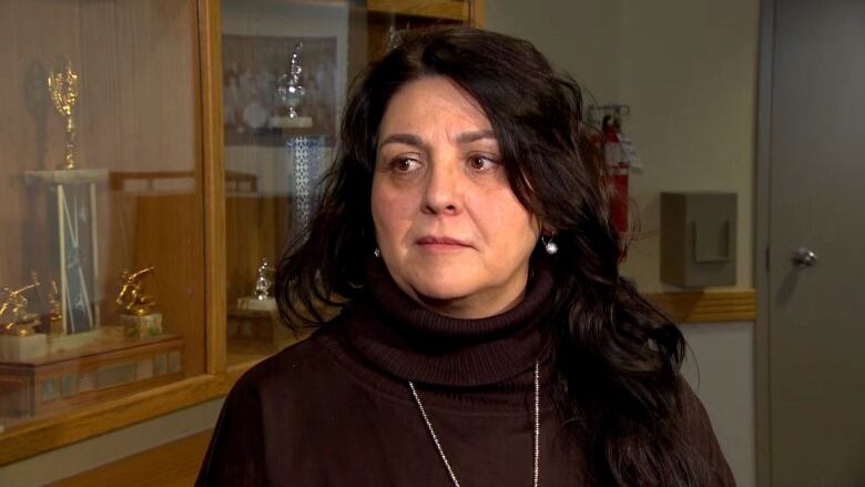 A woman wearing black speaks to reporters off camera. 