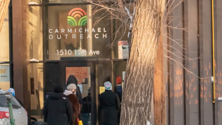 people in winter clothes lined up outside a building