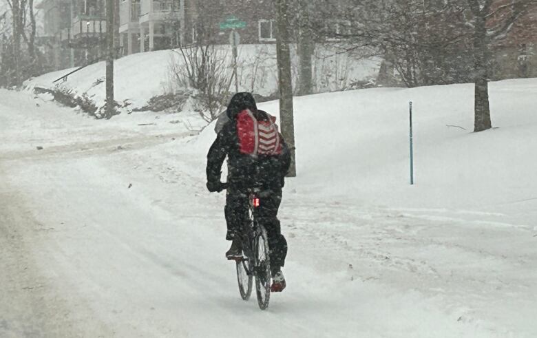 A cyclist rides on snow-covered streets