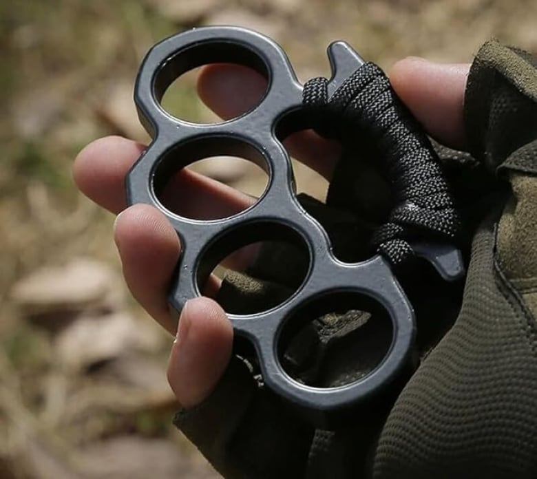 Brass knuckles in someone's hand.