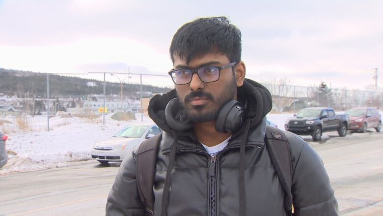 A man stands outside near a Metrobus waiting area. 