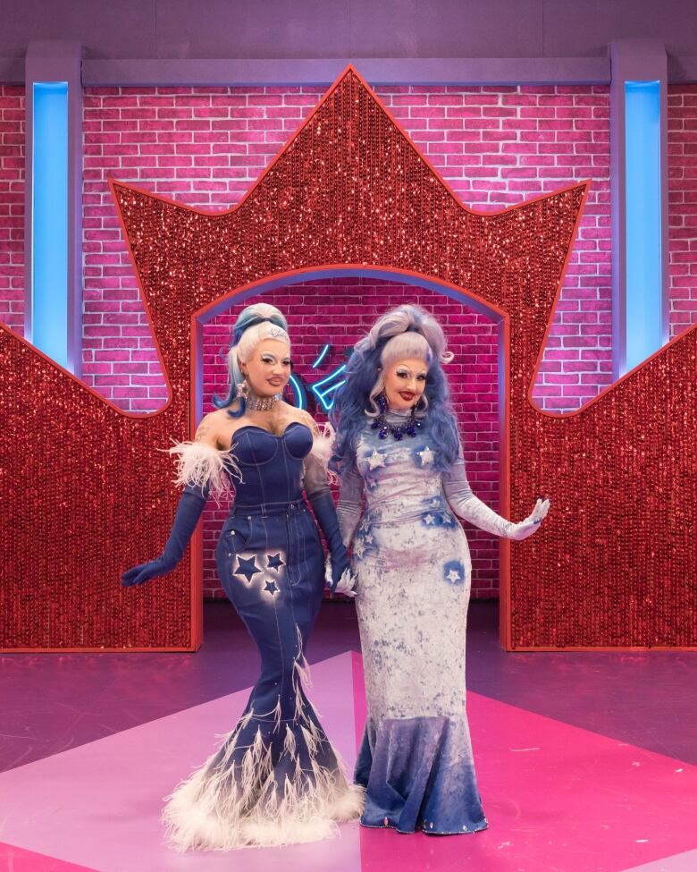 A drag queen and their mother stand on the catwalk dressed alike