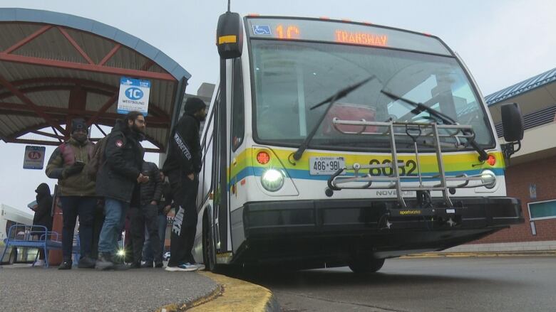 Riders entre a city bus at the downtown terminal. 