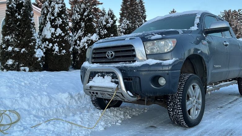 A truck in a driveway plugged in to block heater.