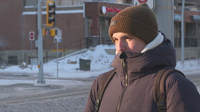 Young man bundled up in toque and winter clothes speaks to reporter on Edmonton street.