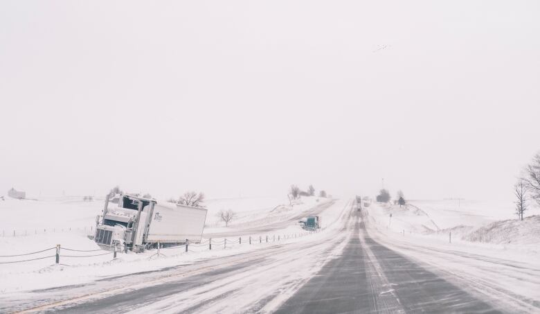 Truck stuck in ditch, surrounded by snow