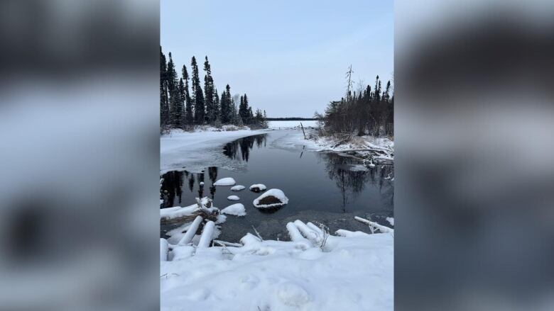 A partially snow-covered body of water is seen on an overcast day.