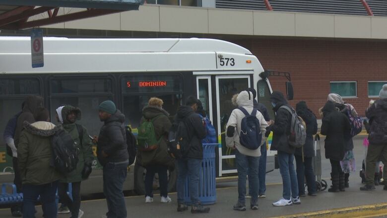 A line of people preparing to board a bus.